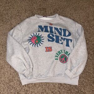 Woman’s Edikted “Mind Set” grey sweatshirt with multi-coloured design.